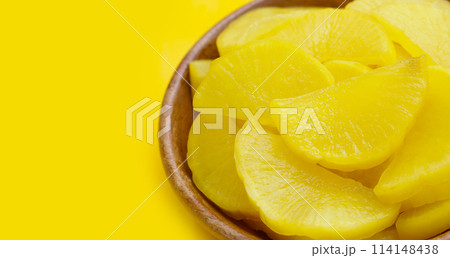 Sweet and tart slices of yellow pickled daikon, known as takuan in Japan and danmuji in Korea. Sweet and tart slices of yellow pickled daikon, known as takuan in Japan and danmuji in Korea. 114148438