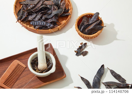 Flat lay ingredients for the manufacture of products from black locust fruit, a rectangle wooden tray, a tray and a basket by rattan. Blank space, top view photo 114148706