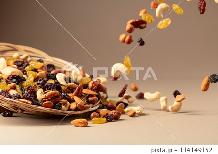 Flying dried fruits and nuts on a beige background. 114149152