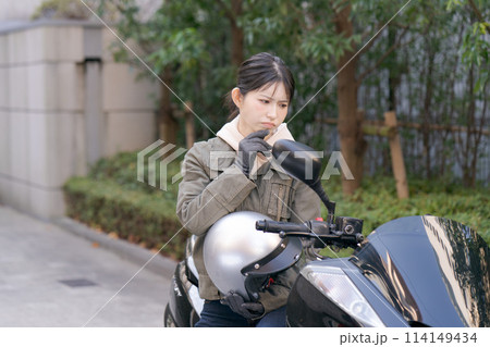困った表情の女性バイカー 114149434