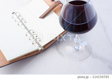 リング式のシステム手帳と赤ワインのグラス リング式のシステム手帳と赤ワインのグラス 114150785