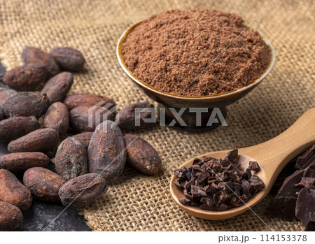 Cocoa beans and cocoa pod on a wooden surface. 114153378