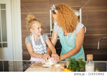 Mother and child daughter preparing the dough, baking cookies Mother and child daughter preparing the dough, baking cookies 114153642