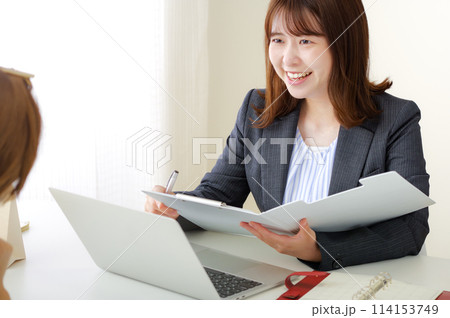 仕事の打ち合わせをするスーツ姿の女性 仕事の打ち合わせをするスーツ姿の女性 114153749