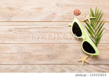 sunglasses with seashell lying on table background. Sunglasses on summer background. Top view flat lay with copy space for text sunglasses with seashell lying on table background. Sunglasses on summer background. Top view flat lay with copy space for text 114153813