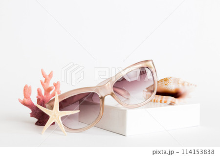 sunglasses with seashell lying on table background. Sunglasses on summer background. Top view flat lay with copy space for text 114153838