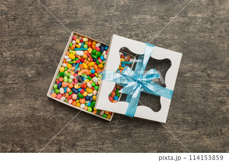 Box with sweet chocolate candies on color background, Various candy sweets. Valentines day gift box. Top view flat lay with copy space Box with sweet chocolate candies on color background, Various candy sweets. Valentines day gift box. Top view flat lay with copy space 114153859