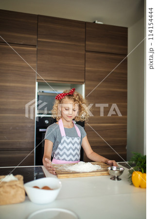 Woman and cute daughter cooking on kitchen, making dough for birthday party. Woman and cute daughter cooking on kitchen, making dough for birthday party. 114154444