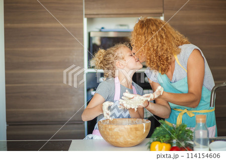 Mother and child daughter girl having fun while making dinner at the kitchen. 114154606
