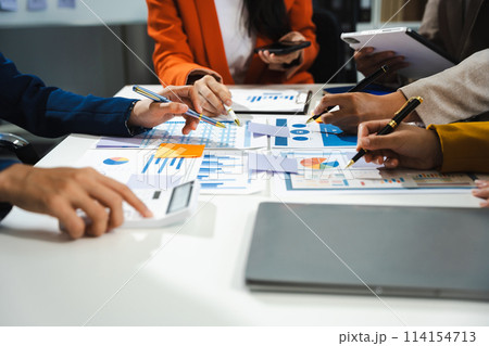Business, technology and office concept - business team with laptop, tablet pc computer and papers having discussion in modern office. 114154713