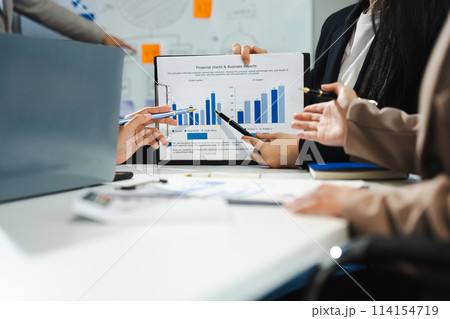 Business, technology and office concept - business team with laptop, tablet pc computer and papers having discussion in modern office. 114154719