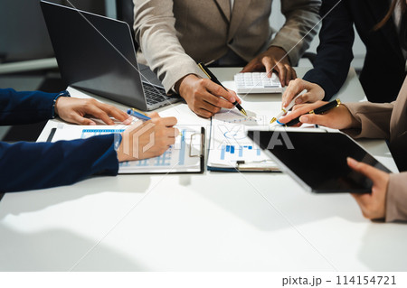 Business, technology and office concept - business team with laptop, tablet pc computer and papers having discussion in modern office. 114154721