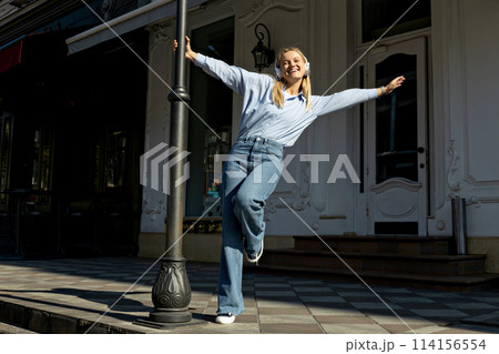 Girl in headphones on the street, close-up portrait. 114156554