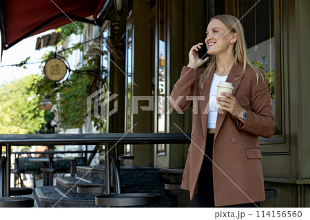 A girl in a business suit with a phone. 114156560