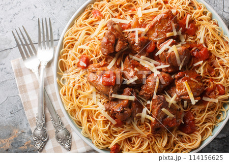 Moshari Kokkinisto or Tas Kebap Greek Veal Stew in a Tomato Sauce with pasta spaghetti closeup on the plate. Horizontal top view 114156625