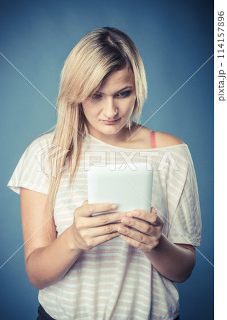 Young woman with tablet on blue 114157896