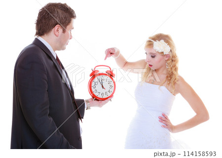 Groom holding big red clock yelling and bride Groom holding big red clock yelling and bride 114158593