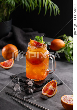 Freshly squeezed blood orange juice with ice, mint and a slice of fruit in a jar  114158827