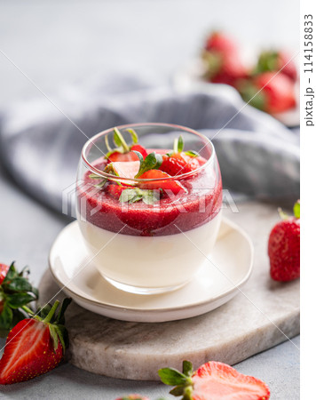 Panna cotta with strawberry and cream in glass with fresh berries on a marble board Panna cotta with strawberry and cream in glass with fresh berries on a marble board 114158833