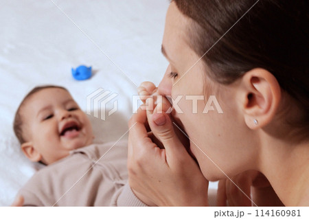 Young mother, kissing her baby boy at home. Family concept. Closeup portrait of loving mother young woman kissing little kid, home interior Young mother, kissing her baby boy at home. Family concept. Closeup portrait of loving mother young woman kissing little kid, home interior 114160981