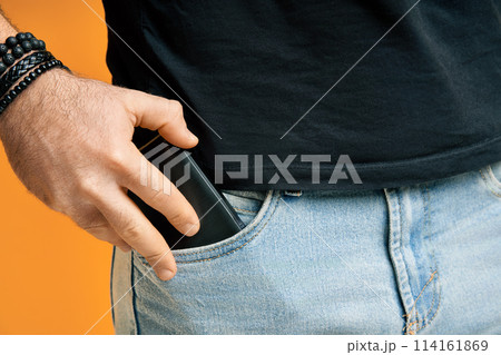 Closeup man take out mobile phone of his pocket Closeup man take out mobile phone of his pocket 114161869