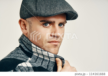 Trendy man in tweed hat over soft white background with copy space 114161888