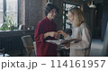 People colleagues shaking hands checking business documents and talking standing in creative office together. Start-up and coworking concept. 114161957