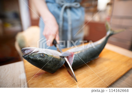魚の頭を切り落とす女性 114162668