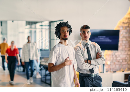 A group of colleagues, including an African American businessman and a young leader in a shirt and tie, pose together in a modern coworking center office, representing a dynamic blend of A group of colleagues, including an African American businessman and a young leader in a shirt and tie, pose together in a modern coworking center office, representing a dynamic blend of 114165410