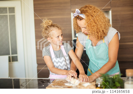 Mother and child daughter preparing the dough, baking cookies Mother and child daughter preparing the dough, baking cookies 114165658