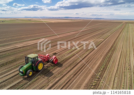 Aerial shots of Farmers operating tractors equipped with seed drills. 114165818