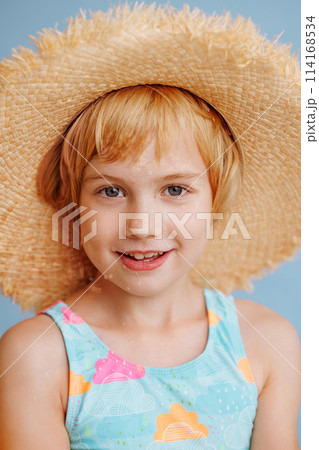 A young girl is smiling and wearing a straw hat 114168534