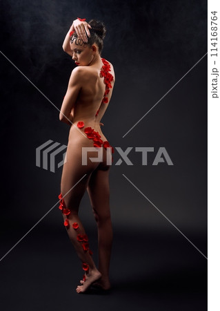 Naked woman with petals on her body embracing herself Naked woman with petals on her body embracing herself 114168764