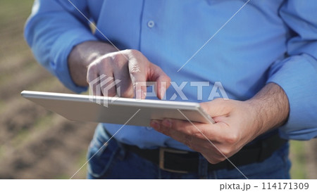 Businessman digital agricultural farmer with tablet. Hands male professional using tablet. Creation planting plans harvest schedules labor allocation aspects of agricultural business farm management. Businessman digital agricultural farmer with tablet. Hands male professional using tablet. Creation planting plans harvest schedules labor allocation aspects of agricultural business farm management. 114171309