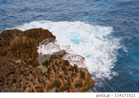 Cinematic aerial landscape shots of the beautiful island of Nusa Penida. Huge cliffs by the shoreline and hidden dream beaches with clear water and foaming wave. 114171821