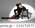 Beautiful woman in retro style in a black bodysuit and a bow in her hair in full length posing on a gray background. Beauty of body and face 114172675