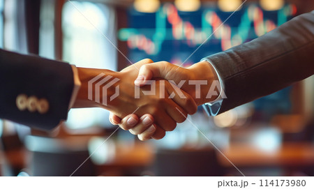 Two men shake hands in a business setting Two men shake hands in a business setting 114173980