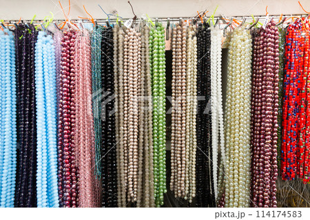 Beads from various gemstones on the showcase of jewelry store Beads from various gemstones on the showcase of jewelry store 114174583