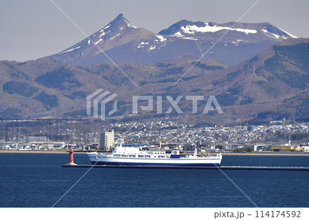 春の北海道函館市函館港を出港する津軽海峡フェリーと残雪の駒ヶ岳の風景を撮影 114174592