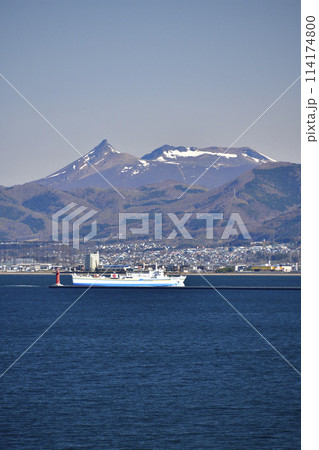 春の北海道函館市函館港に入港する津軽海峡フェリーと残雪の駒ヶ岳の風景を撮影 114174800