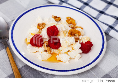 Farm cottage cheese filled with large amount of honey with walnut and raspberry. 114174996