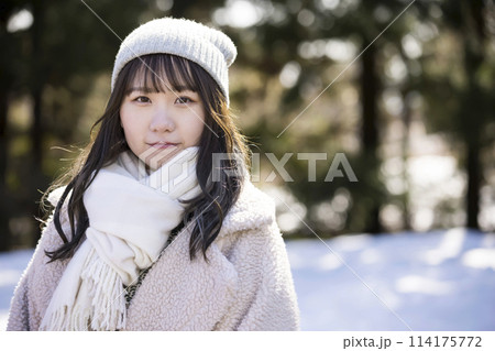 積雪の前に立つ若い女性 114175772