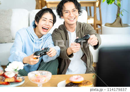 リビングでゲームをするカップル	 114179837