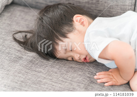家のソファで昼寝する日本人の男の子 114181039