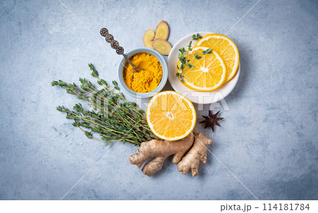 Flat lay from ingredients for a ayurvedic drink. Turmeric powder, ginger, thyme Flat lay from ingredients for a ayurvedic drink. Turmeric powder, ginger, thyme 114181784