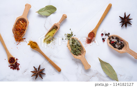 Various wooden spoons of spices on marble background Various wooden spoons of spices on marble background 114182127