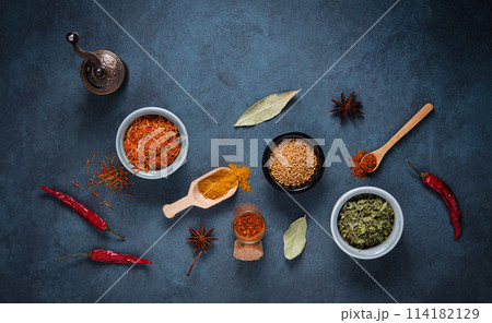 Various bowls and spoons of turkish spices on dark blue background Various bowls and spoons of turkish spices on dark blue background 114182129