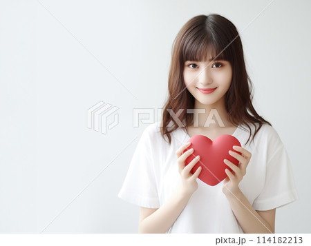 ハートを持つ笑顔の女性 114182213