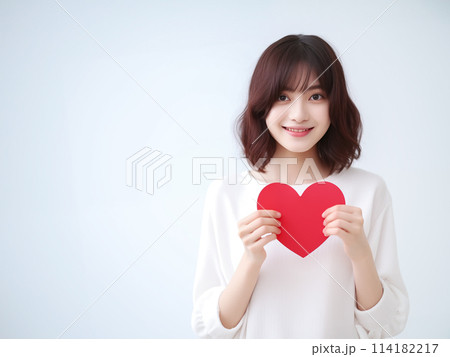 ハートを持つ笑顔の女性 114182217