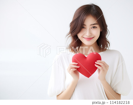 ハートを持つ笑顔の女性 114182218